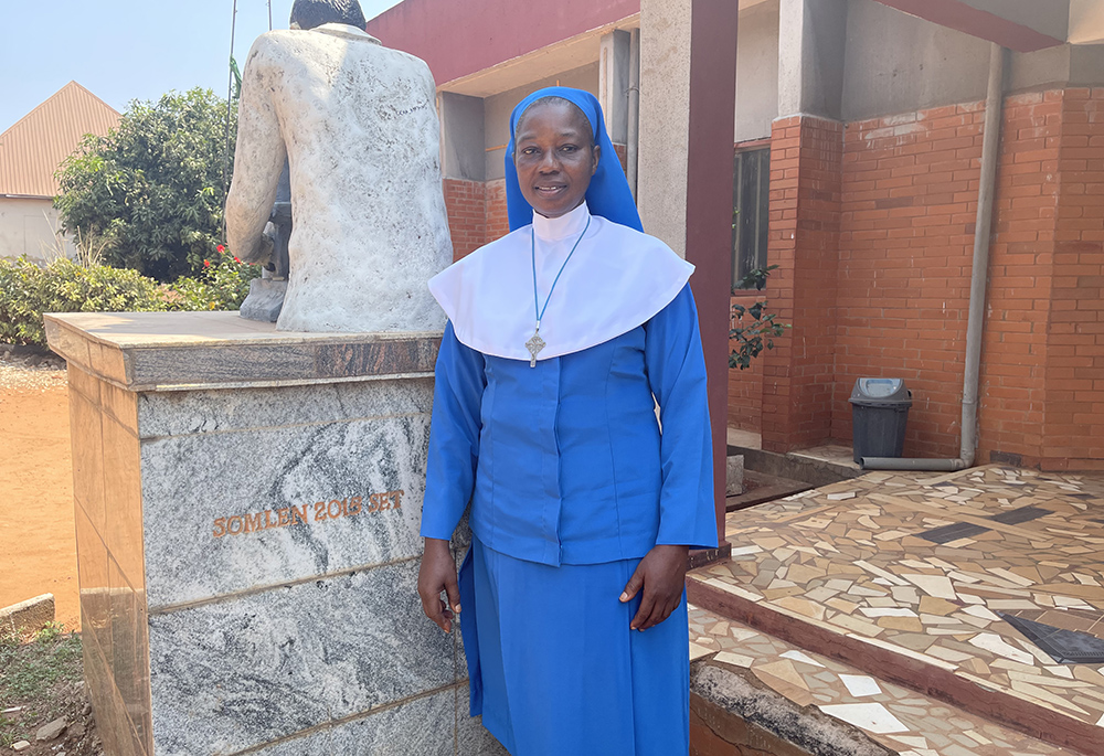 Sr. Adeline Igweonu poses in front of the Daughters of Divine Love School of Medical Laboratory Technicians building in Eha-Alumona, Nigeria. (John Chukwu)