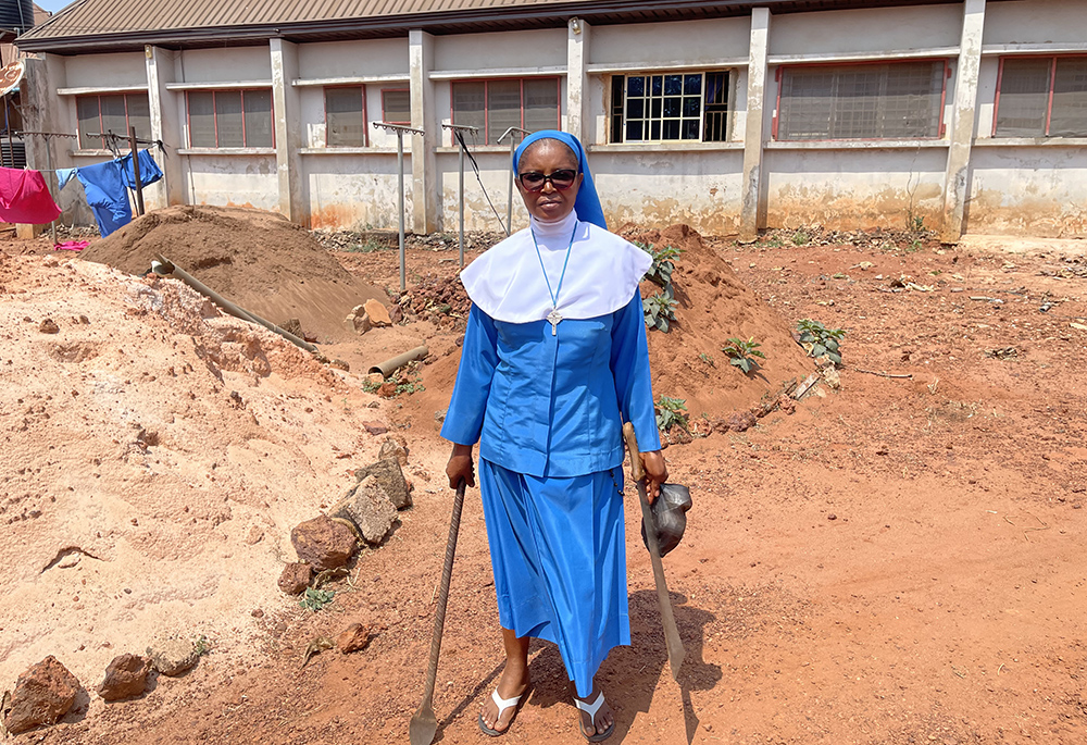 Sr. Mary Imelda Okonkwo poses with farming tools after inspecting the farmland used to support pregnant teenagers at the Daughters of Divine Love Pro-Life Centre in Eha-Alumona, Nigeria. (John Chukwu)