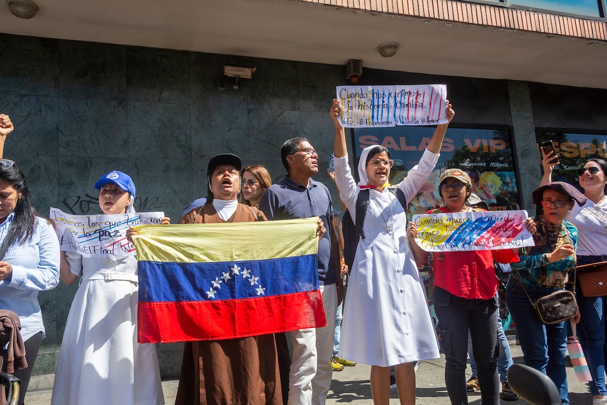 Sisters participate in a rally on Elice Street in Chacao, Caracas, Venezuela, on Jan. 9, 2025, the eve of Nicolás Maduro's inauguration for his third term. Their banners read: "When we unite, history changes," "When fear dies, freedom is born," and "Blessed are those who work for peace." (Courtesy of Jimmy Villalta)