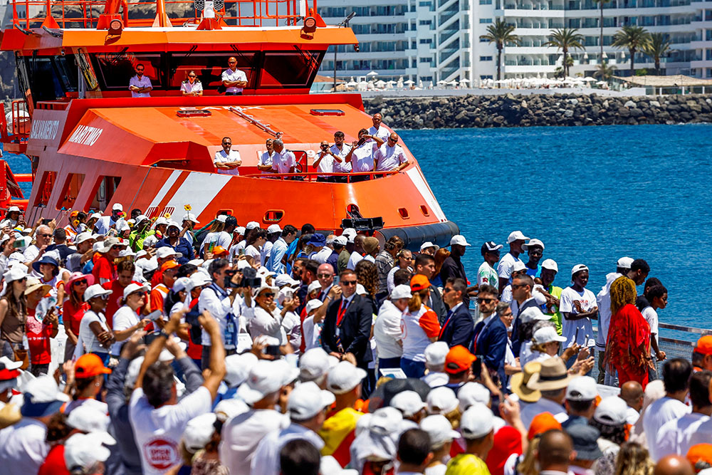 People gather as Pope Leo XIV (not pictured) makes a floral offering to migrants lost at sea at the dock of the Port of Arguineguin in Gran Canaria, Spain, June 11, 2026. (OSV News/Reuters/Borja Suarez)