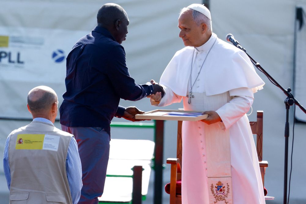 Pope Leo XIV receives a photo collage from Senegalese migrant Theodor Faye at the "Las Raices" migrant center in Tenerife, Canary Islands, Spain, June 12, 2026. (OSV News/Borja Suarez)