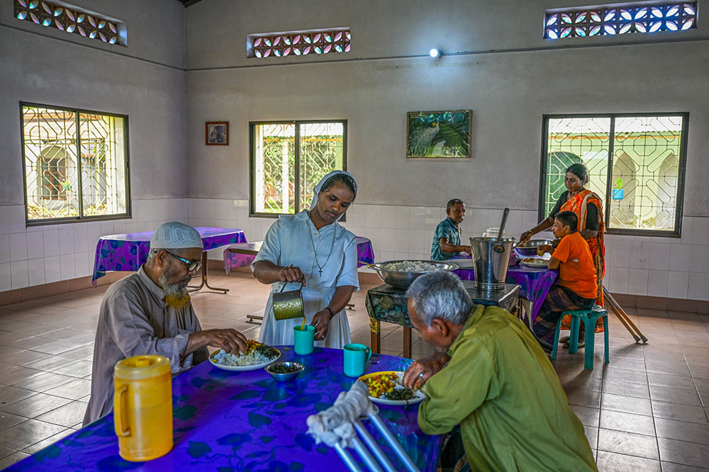 Staff members serve meals in the communal dining hall. The center provides full nutritional support for all residents. (Piyas Biswas)