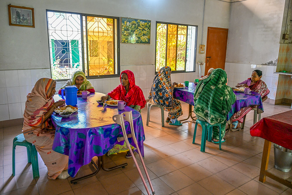 Patients share a meal and conversation. The communal setting helps combat the deep social isolation many feel after being rejected by their home villages. (Piyas Biswas)