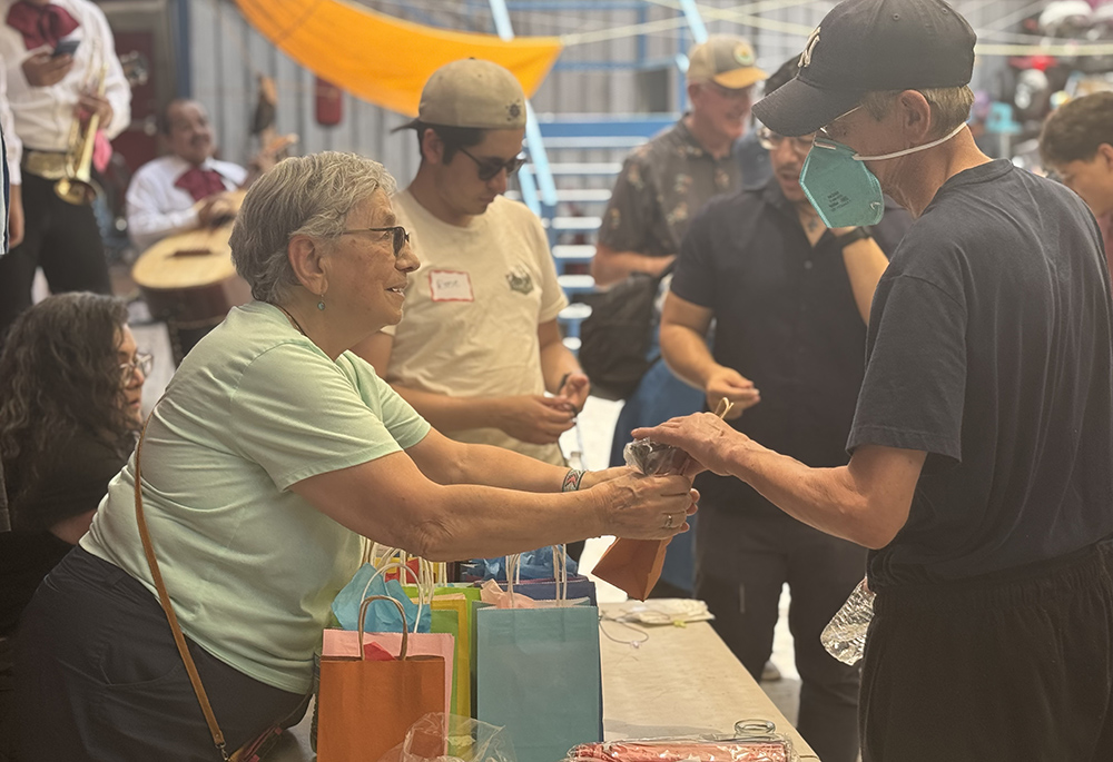 Rochester Franciscan Sr. Phyllis Sellner, of Palm Desert, California, hands goody bags to men at the Cobina Posada del Migrante shelter where sisters and their friends celebrated Father’s Day June 6, 2026, in Mexicali, Mexico. (GSR photo/Rhina Guidos)