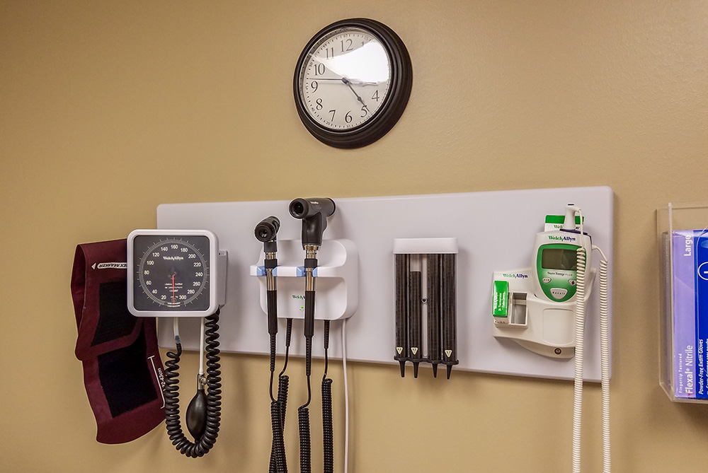 Wall in a medical office with a clock and various medical equipment (Pixabay/Robyn Wright)
