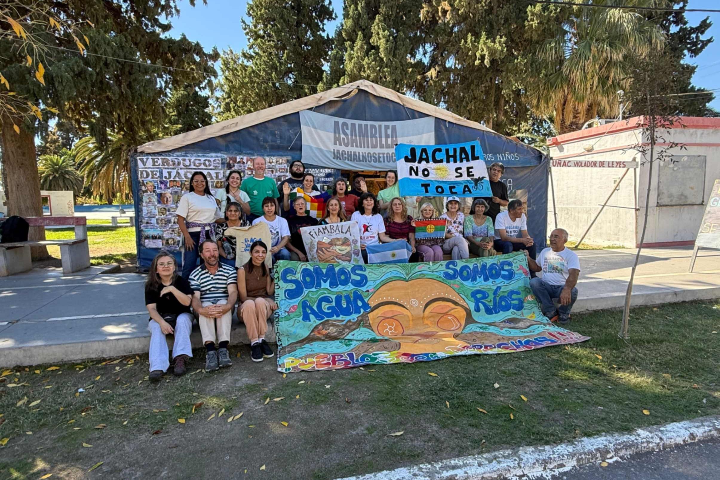 Ana María Siufi, tercera desde la izquierda en la fila del medio, participa en un encuentro frente a la carpa instalada en la plaza como protesta contra la megaminería, en abril de 2026, en Jáchal, provincia de San Juan, Argentina. (Foto: cortesía Ana María Siufi)