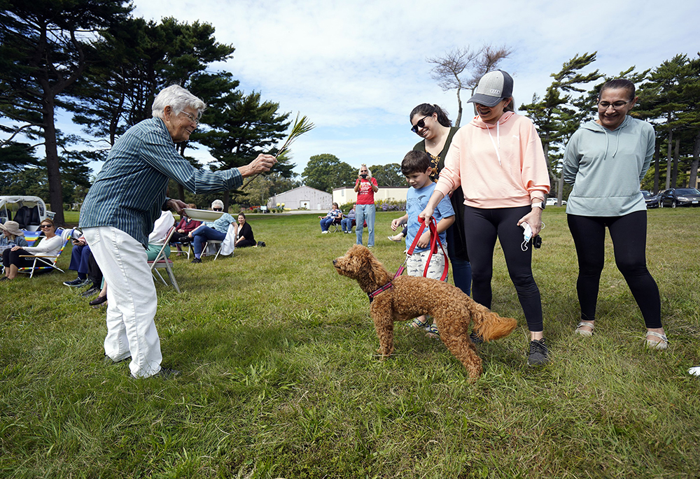 Sr. Mary Lou Buser, a member of the Sisters of St. Joseph of Brentwood, New York, blesses Ellie, a Goldendoodle, during a prayer service marking the Season of Creation at the Sisters of St. Joseph motherhouse Oct. 3, 2021. (CNS/Gregory A. Shemitz)