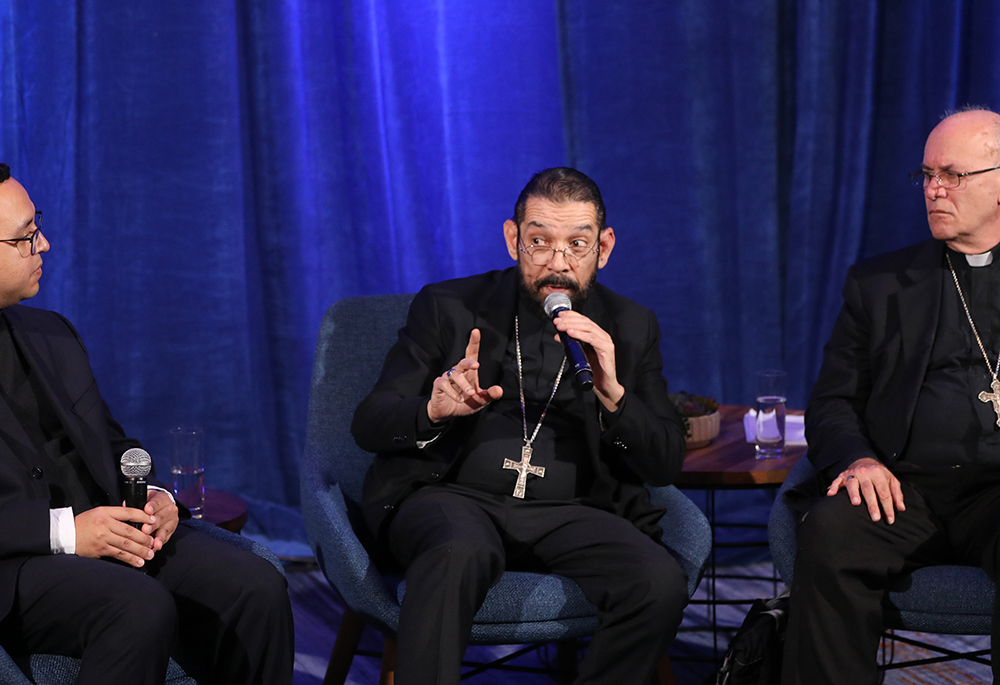 Bishop Daniel E. Flores of Brownsville, Texas, speaks at a news conference during a Nov. 14, 2023, session of the fall general assembly of the U.S. bishops in Baltimore. Also pictured are Fr. Iván Montelongo, of the Diocese of El Paso, Texas, and Bishop Kevin C. Rhoades of Fort Wayne-South Bend, Indiana. (OSV News photo/Bob Roller)