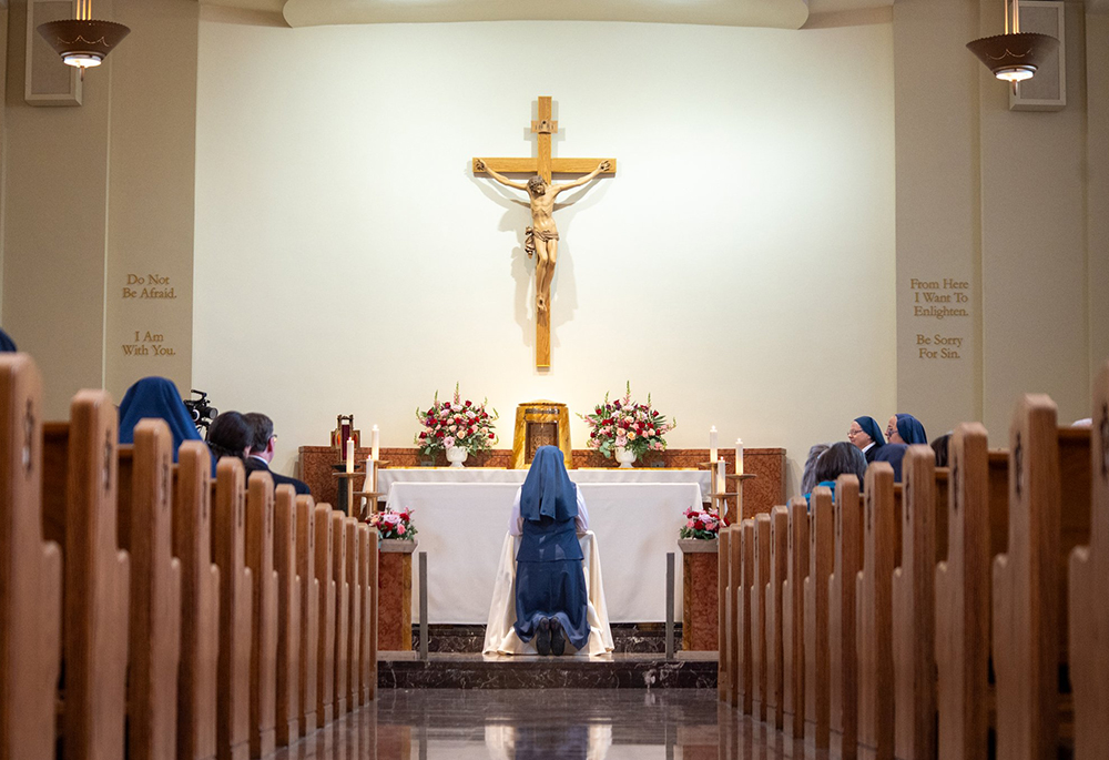 Sr. Catherine Lucia Phoebe Addington of the Daughters of St. Paul in Alexandria, Virginia, is pictured kneeling in prayer during her profession of vows in Boston Feb. 14, 2026. (OSV News/Courtesy of Daughters of St. Paul)
