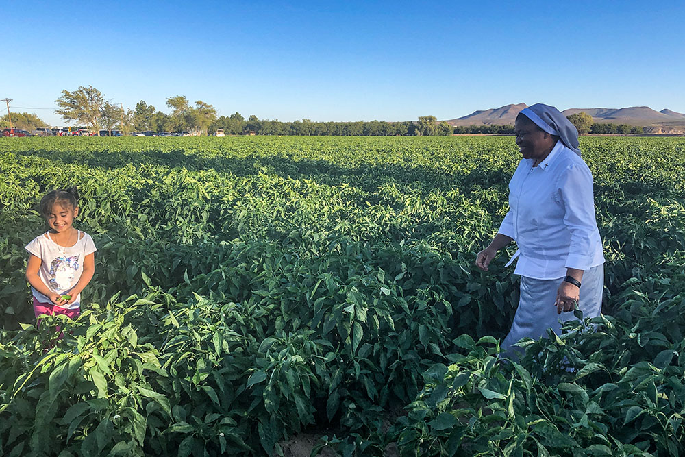 3. Sr. Joanna Okereke talks to a child in the chili fields of Hatch, New Mexico, Sept. 26, 2019, during a visit by U.S. bishops to farmworkers. (Courtesy of Joanna Okereke)