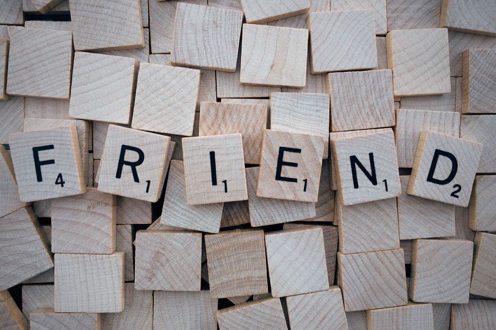 Scrabble tiles spell "friend."