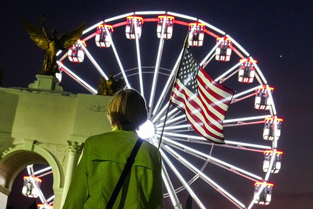 A person carries an American flag at the Great American State Fair, Tuesday, June 30, 2026, on the National Mall in Washington. (AP/Julia Demaree Nikhinson)