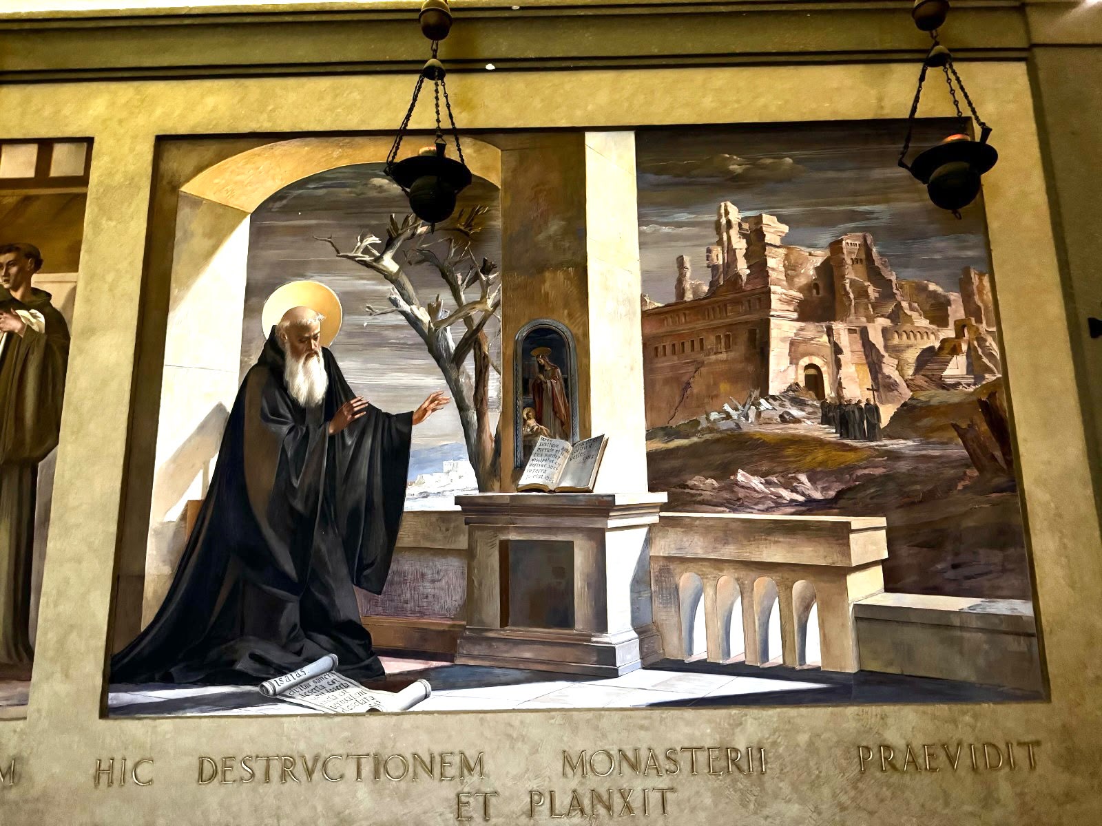 Un fresco en la celda de san Benito en el monasterio de Montecassino, en Cassino, Italia, representa a Benito llorando tras haber previsto la destrucción del monasterio. La inscripción en latín dice: "Aquí previó y lloró la destrucción del monasterio". (Foto: Global Sisters Report/Helga Leija)