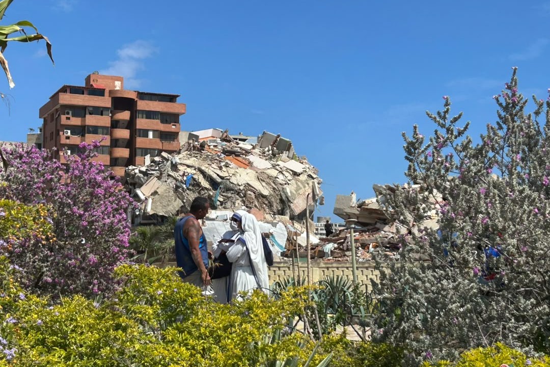 Misioneras de la Caridad, provenientes de India, África, México y Belice, permanecen junto a familiares de personas desaparecidas frente a una de las edificaciones colapsadas por los terremotos. (Foto cortesía: Fabiola Ortega)