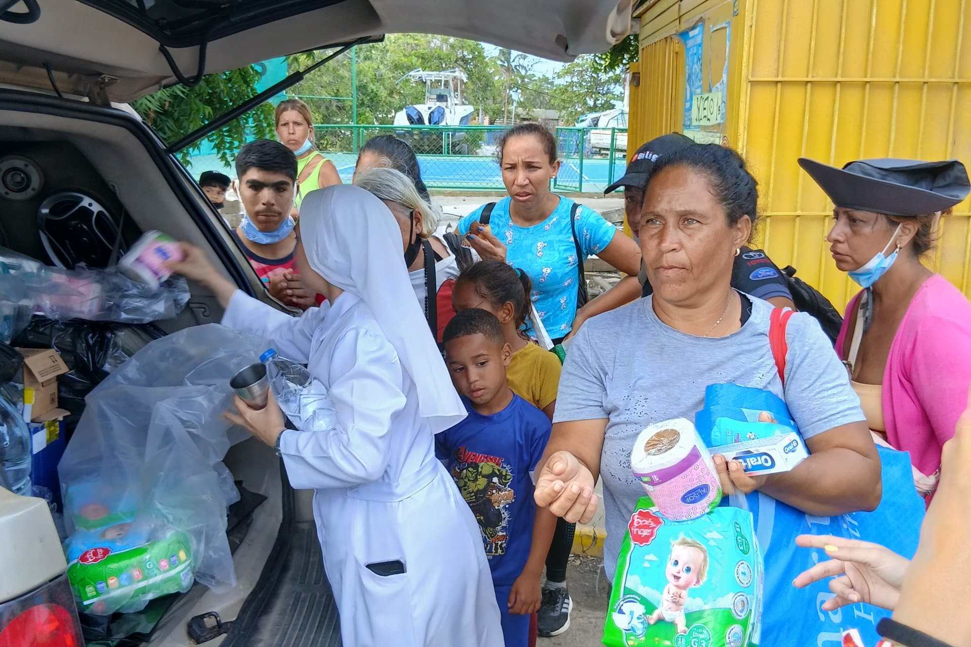 Religiosas de las Siervas del Santísimo Sacramento entregan kits para bebés a mujeres embarazadas y madres con recién nacidos en el sector Catia La Mar, estado La Guaira. (Foto cortesía Siervas del Santísimo Sacramento)
