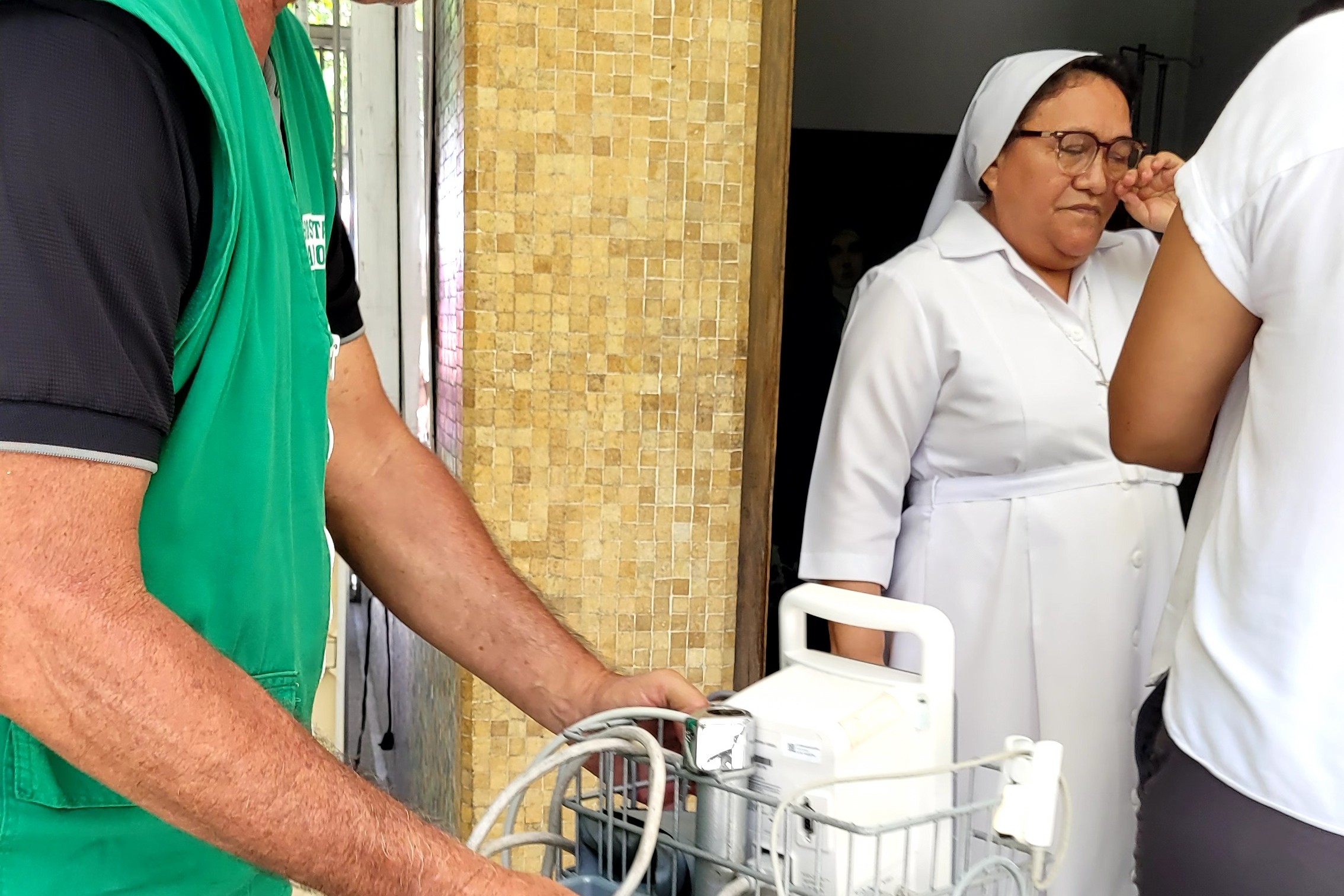 Una religiosa de las Hermanitas de los Pobres de Maiquetía brinda apoyo logístico en el Hospital San José de Maiquetía mientras un voluntario traslada un equipo médico. (Foto cortesía de las Hermanitas de los Pobres de Maiquetía)