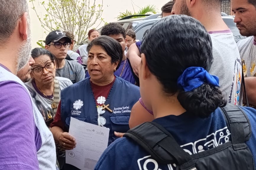 La Hna. María José González, de la comunidad Jesús es Señor y directora de Cáritas Los Teques, entrega alimentos e insumos a personas afectadas en el centro de acopio de Cáritas Los Teques. (Foto: cortesía Cáritas Los Teques)