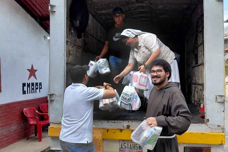 La Hna. Natividad Escudero, de las Hermanas de Nuestra Señora de la Consolación, entrega alimentos en la localidad de El Junquito junto con frailes franciscanos y laicos católicos. (Foto cortesía Hermanas de Nuestra Señora de la Consolación)