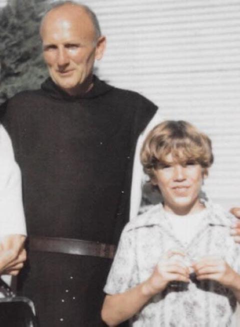 Monk and 12-year-old boy stand together.