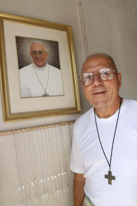 Salesian Brother Sal Sammarco poses next to a portrait of Pope Francis at a workshop in Port Chester, N.Y., Aug. 6, 2015. (CNS/Gregory A. Shemitz)
