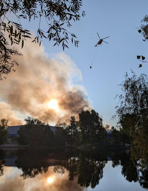 A fire-fighting helicopter collects water to control a fire after Russian missile and drone strikes in Kyiv, Aug. 28, 2025. (OSV News/Reuters)