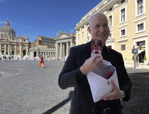 Fr. James Martin, a New York-based Jesuit, shows a commemorative photograph of Pope Leo XIV during an interview with The Associated press just outside St. Peter's Square in Rome, Monday, Sept. 1, 2025. (AP Photo/Maria Selene Clemente)