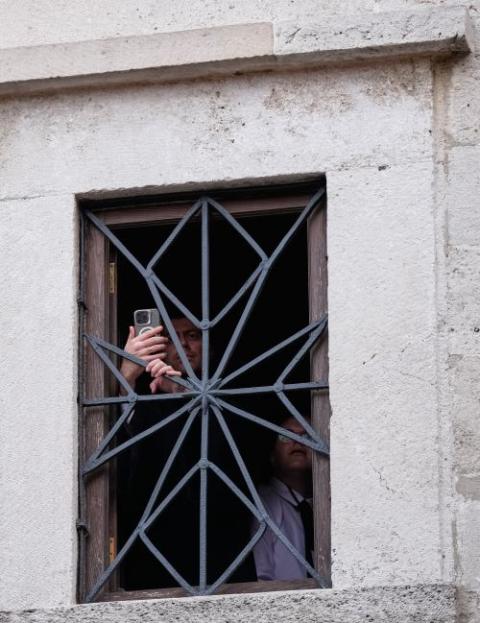People stand at the window of a building in the compound of the Patriarchal Church of Saint George where Pope Leo XIV and Ecumenical Patriarch Bartholomew attended the Doxology in Istanbul Nov. 29.