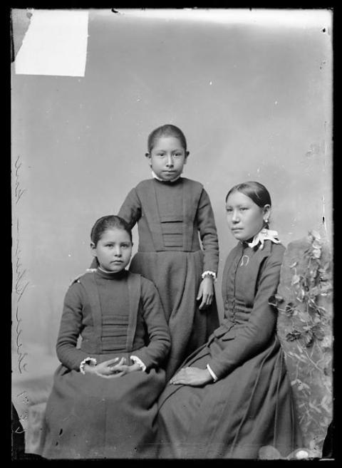 Three girls pose for boarding school portrait.