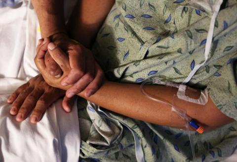 A hospital patient is comforted by a family member in this illustration photo. (CNS/Reuters/Caitlin O'Hara)