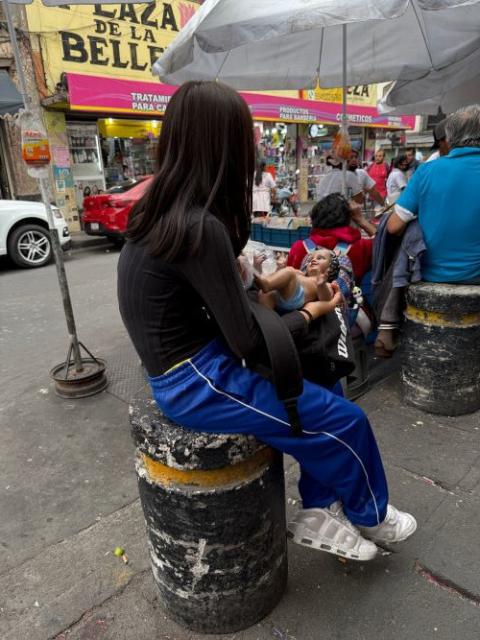 A young girl sits with her Baby Jesus figurine Jan. 27 outside a Mexico City market that sells, repairs and dresses the plaster likenesses of the Christ Child for a blessing on Candlemas, celebrated Feb. 2. (Anita Snow) 
