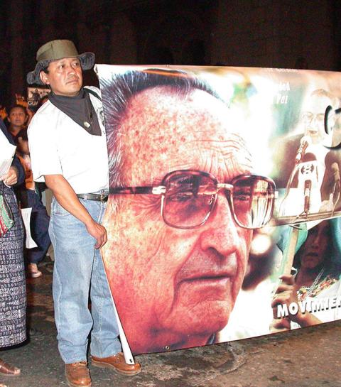 A Guatemalan man holds the end of a banner featuring a photo of the late Auxiliary Bishop Juan Gerardi Conedera April 26, 2003, in Guatemala City. Gerardi was killed April 26, 1998, two days after his release of a report detailing human rights abuses by government security forces during Guatemala's lengthy civil war. (CNS/Paul Jeffrey)