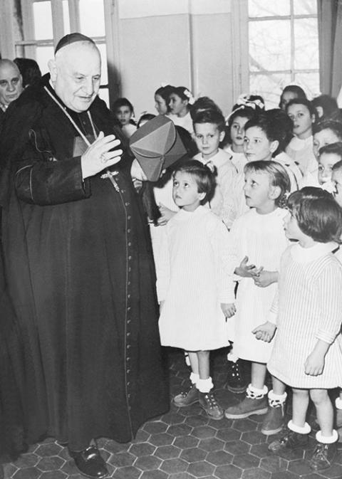 Then-Cardinal Angelo Giuseppe Roncalli, Pope John XXIII from 1958 to 1963, is pictured in an undated photo visiting with school children. (OSV News/KNA)