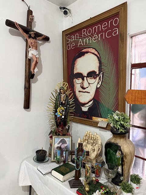 A prayer corner is adorned with a framed portrait of St. Oscar Romero, rosaries, prayer cards and miniature saint statues in a migrant shelter in Ciudad Juarez, Mexico. (NCR photo/Brian Fraga)