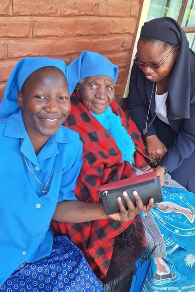 Sr. Sandra Ndingwa, right, unit leader of the Presentation Sisters of Africa Province, greets Sr. Luiza Dzikolidaya, center, cofounding member of the Presentation Sisters of the Virgin Mary of Dedza Diocese, as another sister takes a picture. (Courtesy of Sr. Sandra Ndingwa)