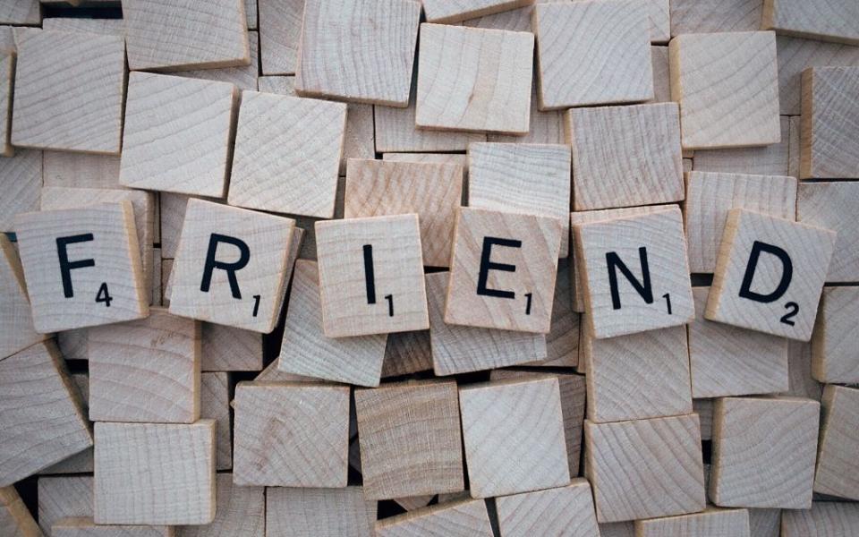 Scrabble tiles spell "friend."