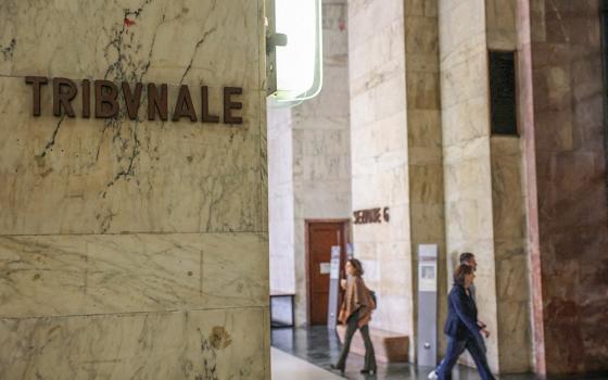 A sign displays the tribunal court location, as people walk along a corridor at Milan Court of Justice, Italy, April 26, 2024. A Sister of Charity in northern Italy was placed under house arrest after a nearly four-month investigation by prosecutors revealed she allegedly used her prison ministry to connect local mafia bosses with inmates. (OSV News/Reuters/Claudia Greco)