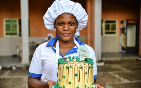 A student at the Divino Amore Vocational Institute in Nigeria holds a cake she made after a baking session. (Patrick Egwu)