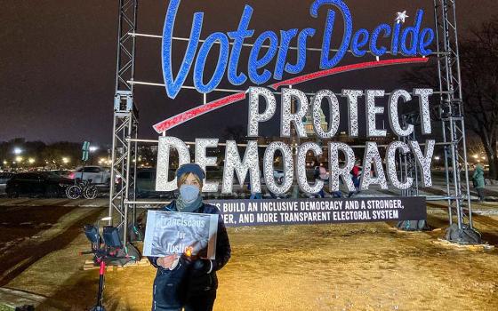Michele Dunne poses Jan. 6, 2022, in Washington during an event in observance of the first anniversary of the attack on the U.S. Capitol in 2021. Dunne, a lay Franciscan, took part in the "Fight Fire with Light" interfaith candlelight vigil in Washington, calling on others to defend truth and democracy. (CNS/Courtesy of Franciscan Action Network)
