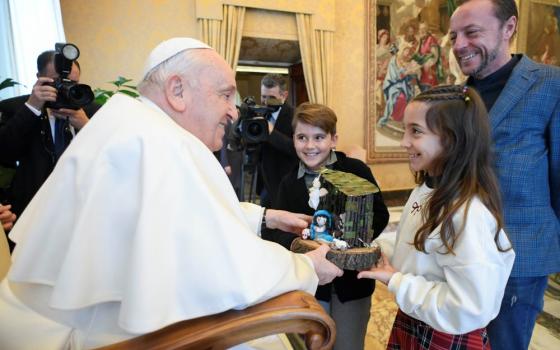 Pope Francis receives a small Nativity scene from a child during a meeting with the Italian Catholic Action movement at the Vatican Dec. 15, 2023. (CNS/Vatican Media)
