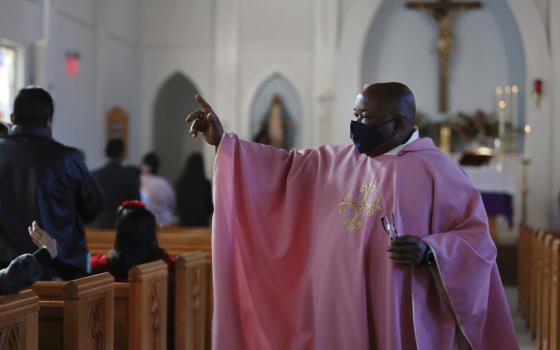 The Rev. Athanasius Abanulo waves to his parishioners after Mass on Dec. 12, 2021, at Immaculate Conception Catholic Church in Wedowee, Ala. (AP Photo/Jessie Wardarski, File)