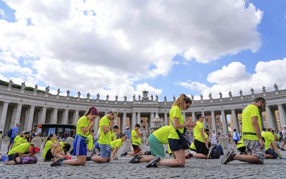 Faithful kneel in prayer proper to the start of Pope Leo XIV's Angelus noon prayer in St. Peter's Square at the Vatican, July 27, 2025. (AP Photo/Gregorio Borgia)