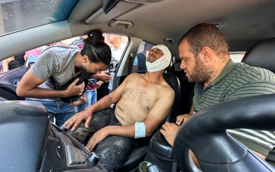 Photographer Hatem Khaled, a Reuters contractor, sits in a car, after being wounded in Israeli strikes on Nasser Hospital in Khan Younis in the southern Gaza Strip, Aug. 25, 2025, that killed journalists, including Reuters contractor and cameraman Hussam al-Masri. (OSV News photo/Ramadan Abed, Reuters)