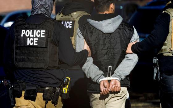 Agents with the Immigration and Customs Enforcement detain a man after conducting a raid at the Cedar Run apartment complex in Denver Feb. 5. (OSV News/Reuters/Kevin Mohatt)