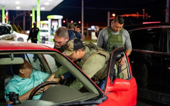 U.S. Immigration and Customs Enforcement officers detain a man from a car stopped by Tennessee Highway Patrol at a gas station in South Nashville, Tennessee, May 10. (OSV News Reuters/Seth Herald)