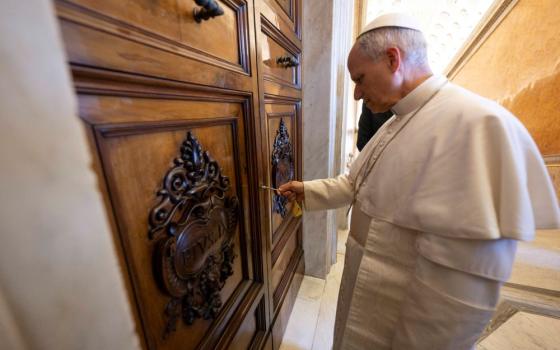 Pope Leo XIV opens the door to the papal apartment in the Apostolic Palace at the Vatican May 11. 