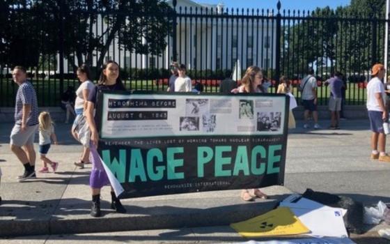 Participants in an Aug. 9 vigil at the White House hold signs decrying war. The event marked the 80th anniversary of the U.S. atomic bombing of Nagasaki, Japan. (Patricia Zapor)