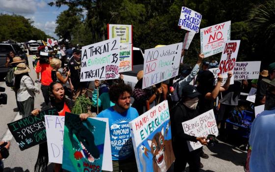 Protesters flank an entrance road at a temporary migrant detention center nicknamed "Alligator Alcatraz" in Ochopee, Fla., July 1, the day U.S. President Donald Trump visited the facility. (OSV News/Reuters/Octavio Jones)