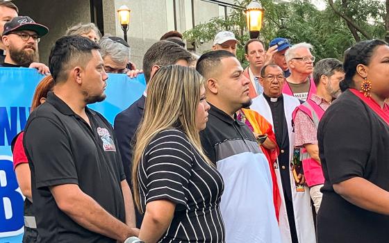 Kilmar Ábrego García, center, stands before a crowd at Baltimore's federal office building before his appointment with Immigration and Customs Enforcement on Aug. 25. Standing next to him is his wife, Jennifer Vasquez Sura. A short time later, Ábrego García was taken into custody. (Patricia Zapor)