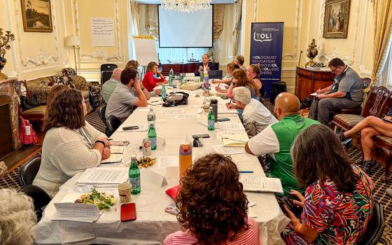Catholic teachers sit around a table listening to Abraham Foxman's story as a Holocaust survivor hidden by a Catholic community, as part of a seminar organized by the Olga Lengyel Institute for Holocaust Studies and Human Rights in New York, July 25, 2025. (NCR photo/Camillo Barone)