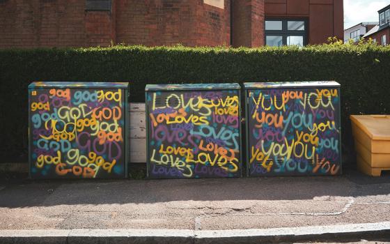"God loves you" is painted on concrete blocks (Unsplash/John Crozier)